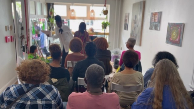 Leslie reading before an audience in Honoring Sonia Sanchez